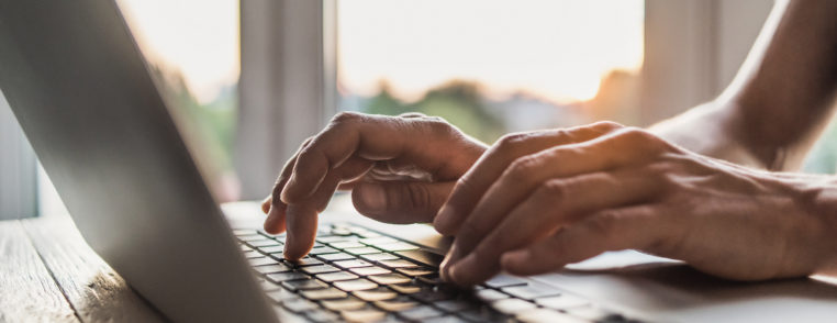 man is typing on laptop
