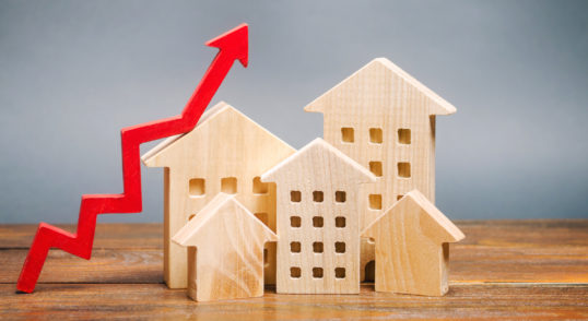 miniature wooden houses and red arrow up