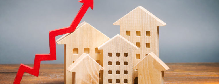 miniature wooden houses and red arrow up